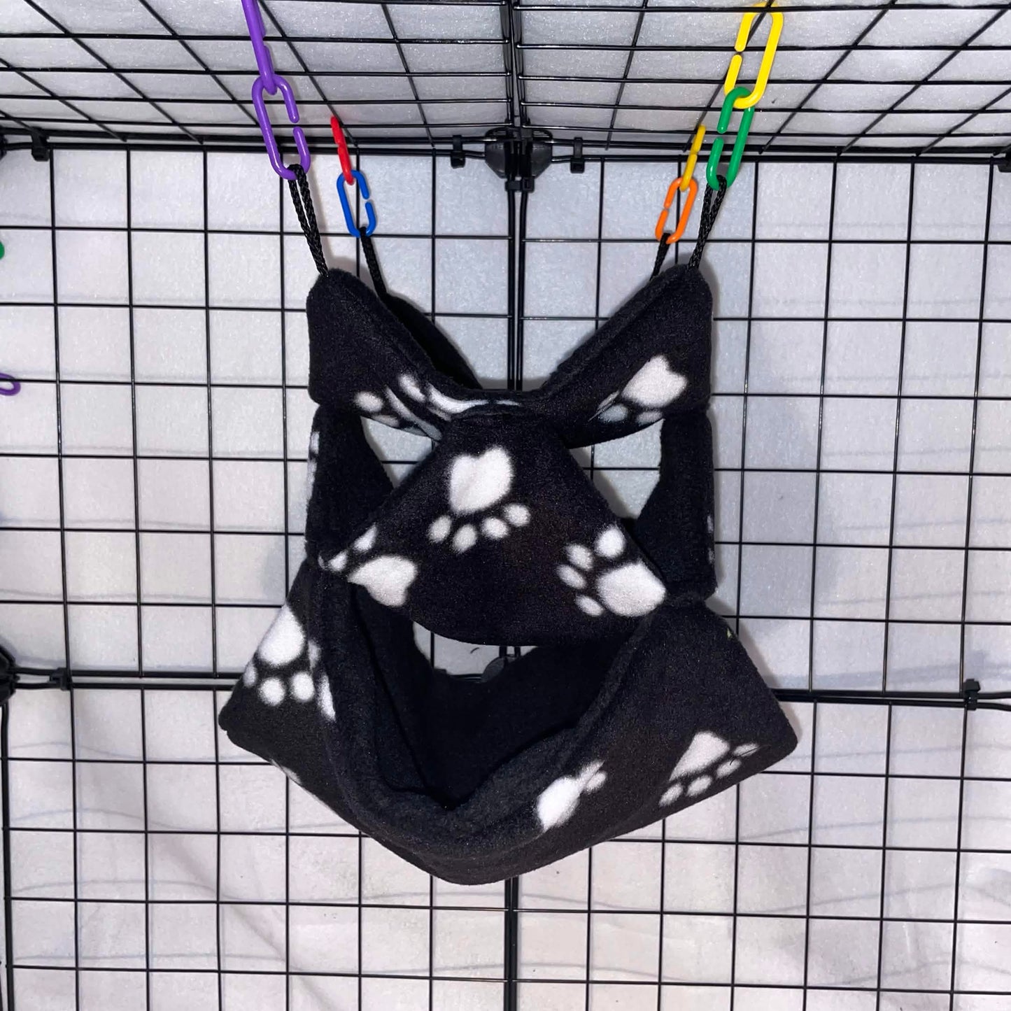 Black paw print 3-tier honeycomb hammock for sugar gliders, made with soft fleece for cozy nesting, climbing, and cage enrichment.