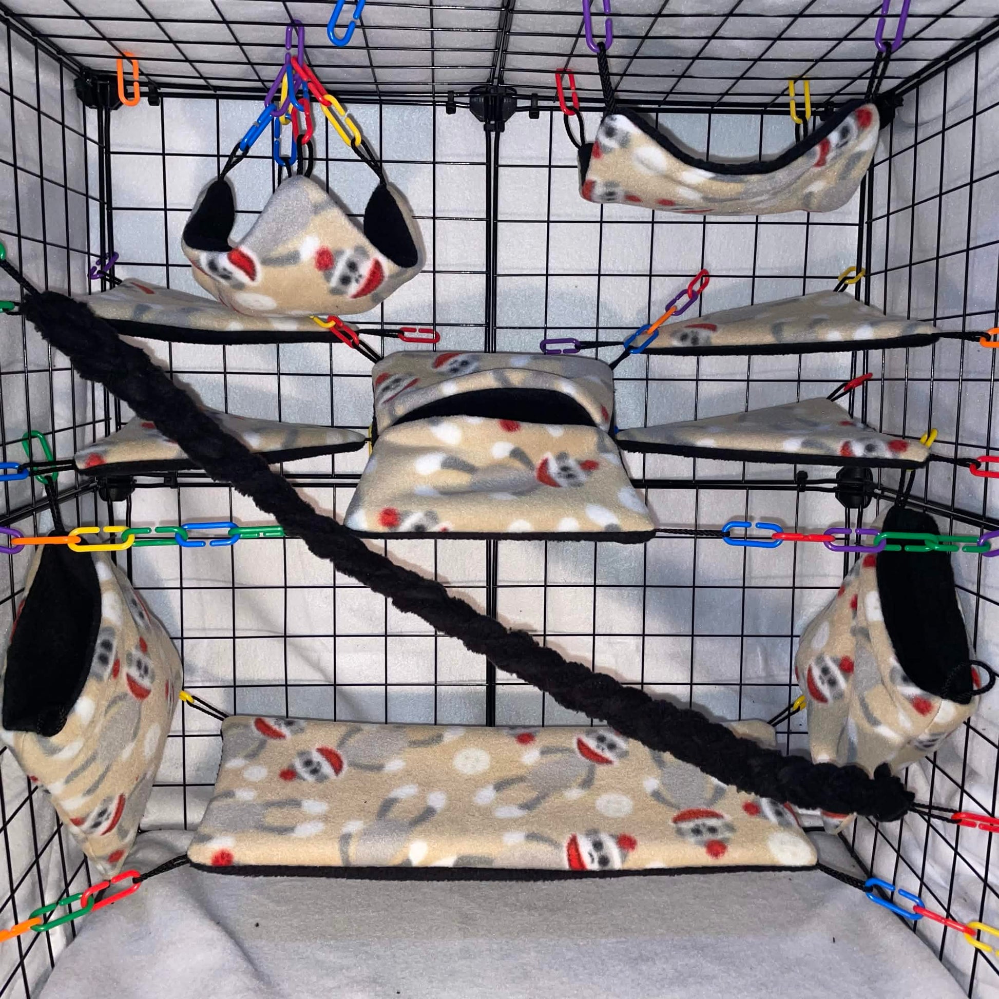 11 pc beige print Monkey sugar glider cage set with fleece hammocks, pouches, shelves, and black braided rope installed in a wire cage.