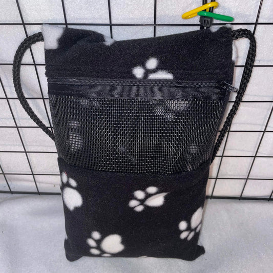 Black paw print sugar glider bonding pouch with black mesh window and shoulder strap shown inside a display cage.