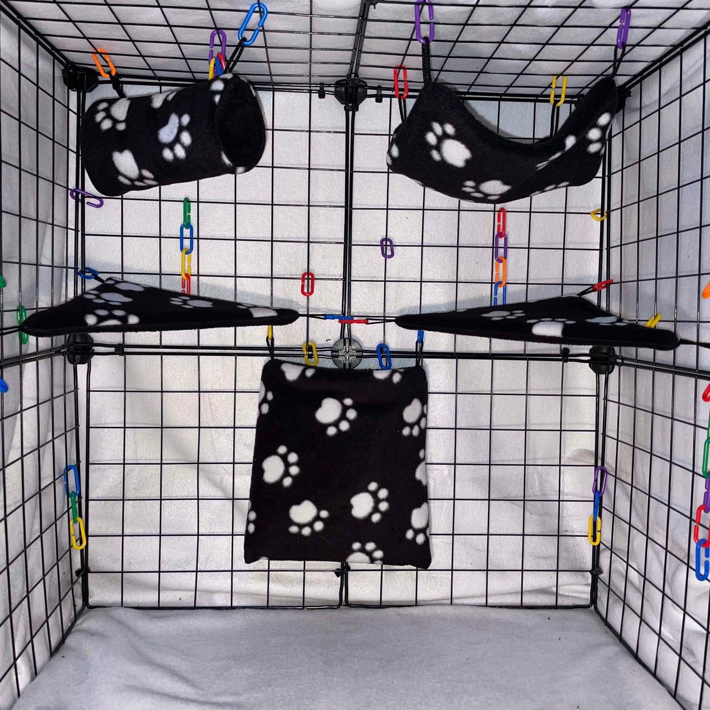 Black paw print sugar glider expansion set with tunnel, hammock, shelves, and fleece accessories. Handmade cage add-ons for cozy glider play.