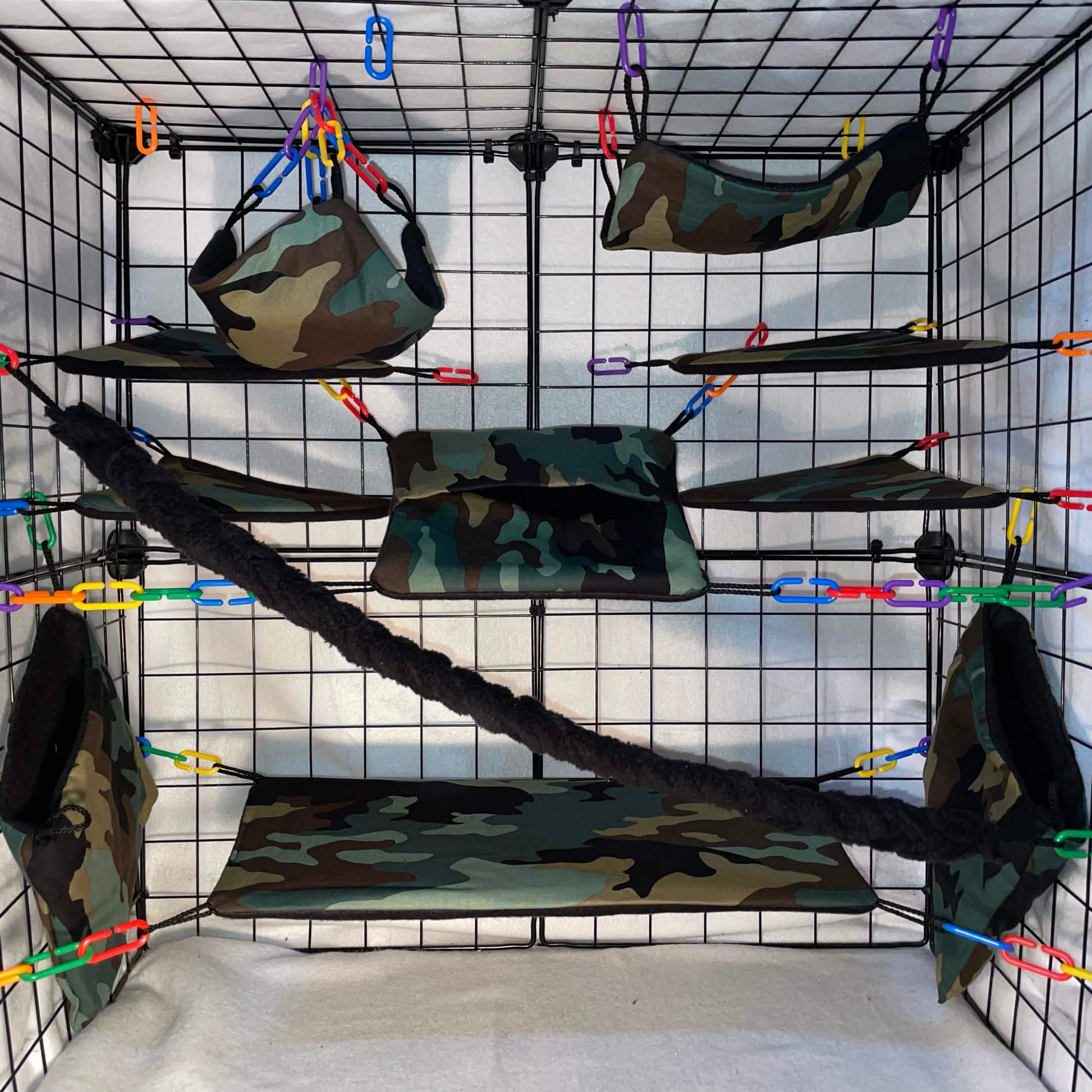 Camo print sugar glider cage set in a display cage with hammocks, pouches, shelf liners, bridge, black fleece vine, and black interior fleece.