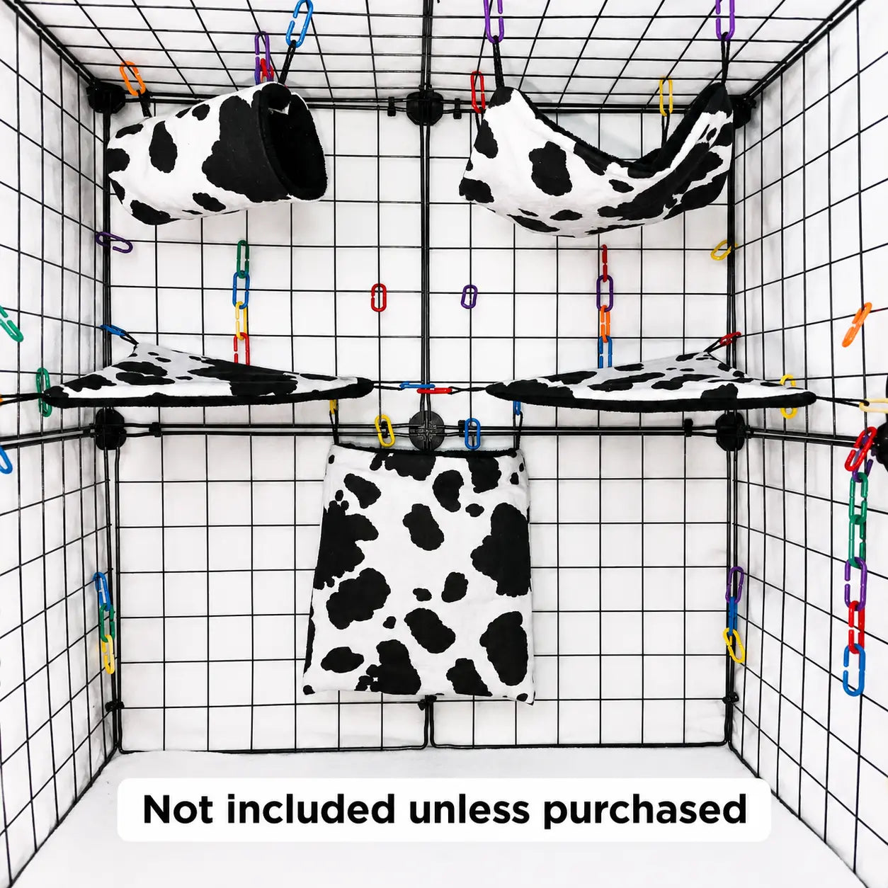 Cow print sugar glider expansion set in a display cage with tunnel, hammock, corner shelves, and hanging pouch with black interior fleece.
