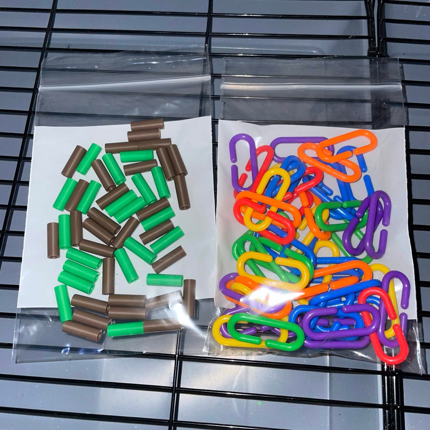 50 assorted colorful sugar glider C-links with 50 brown and green C-Link Locks for securing cage accessories.