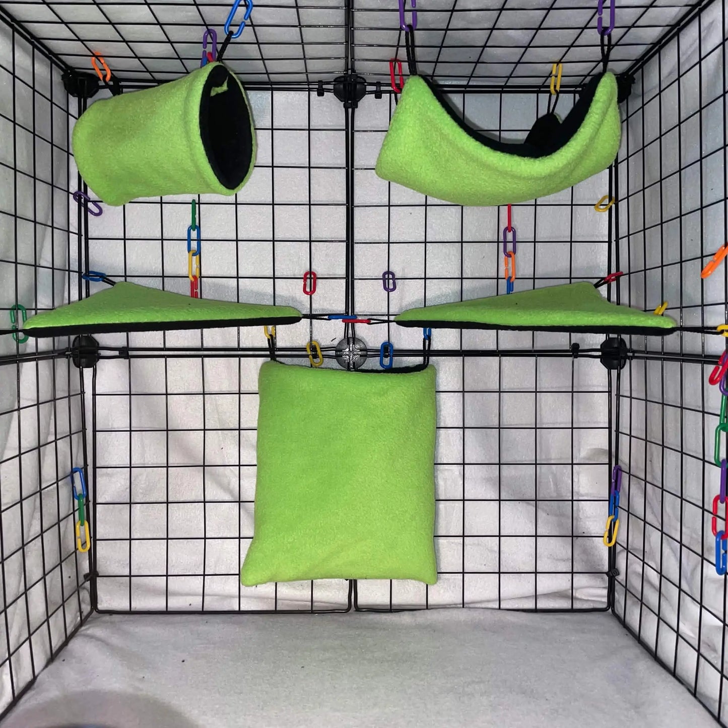 Green sugar glider fleece extension set with pouch, hammock, and corner shelves installed in a wire cage.