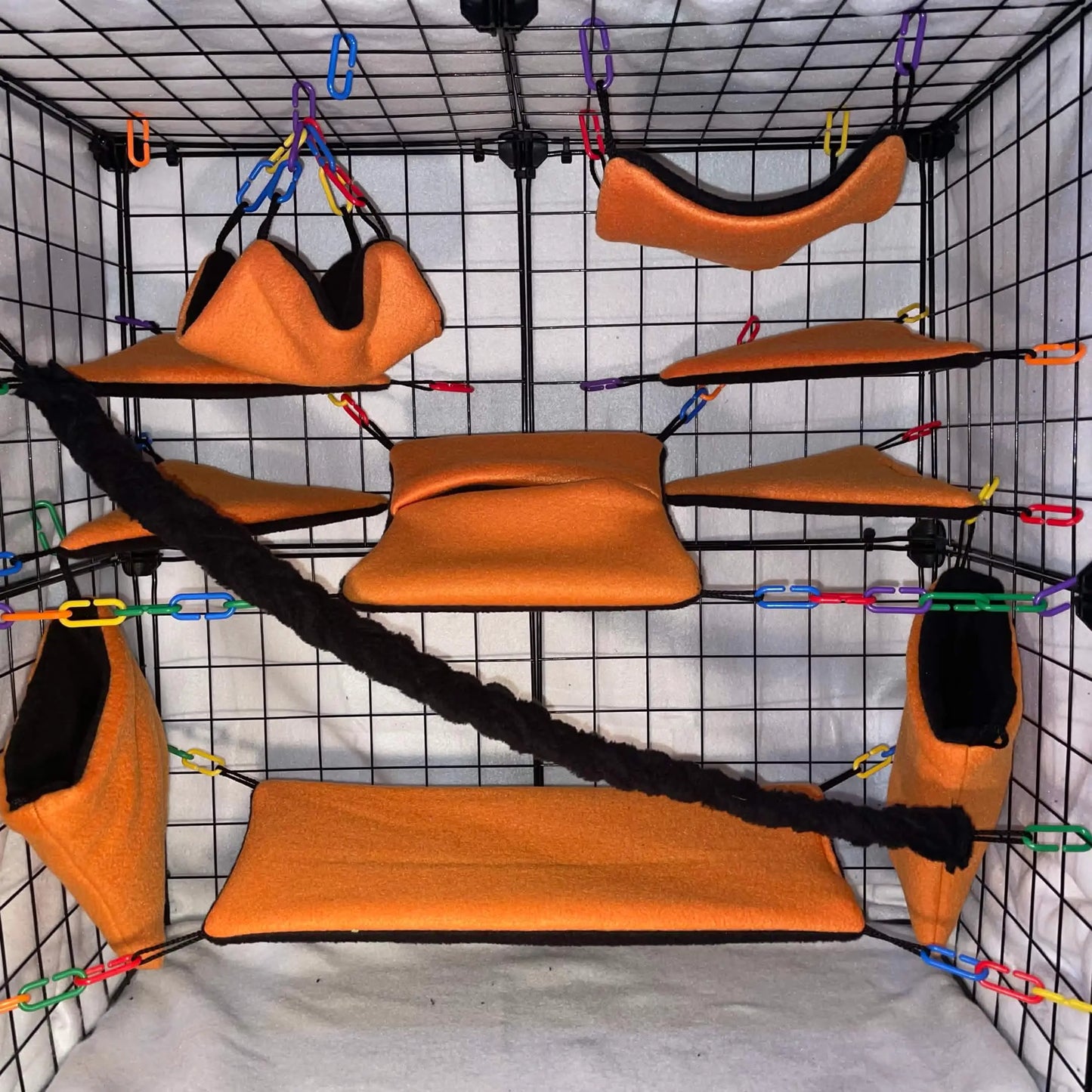 Sugar glider pet cage display with orange hammock platforms and a black rope for climbing
