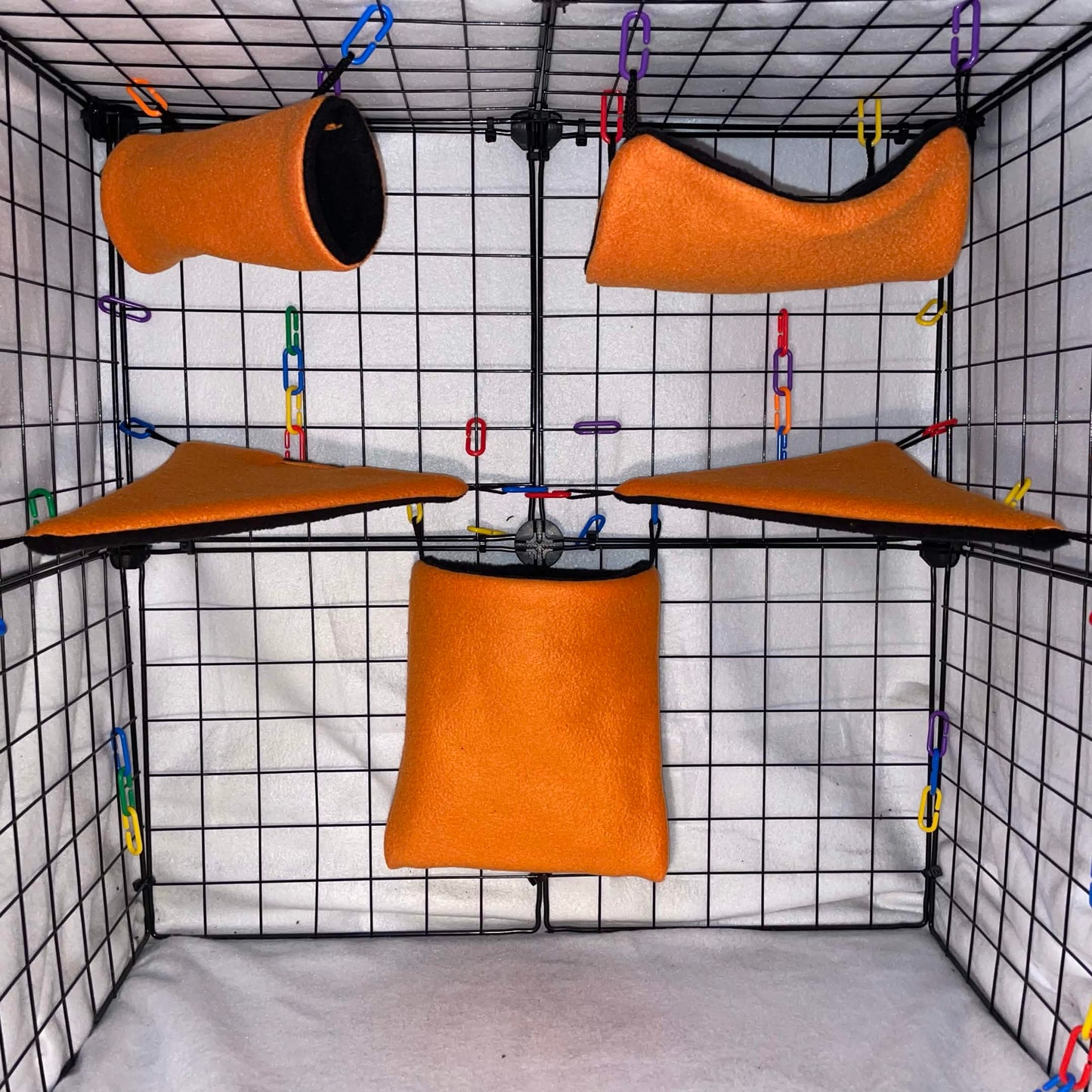Orange sugar glider cage set with black interior, hammocks, tunnel, pouch, and corner shelves shown in a display cage.