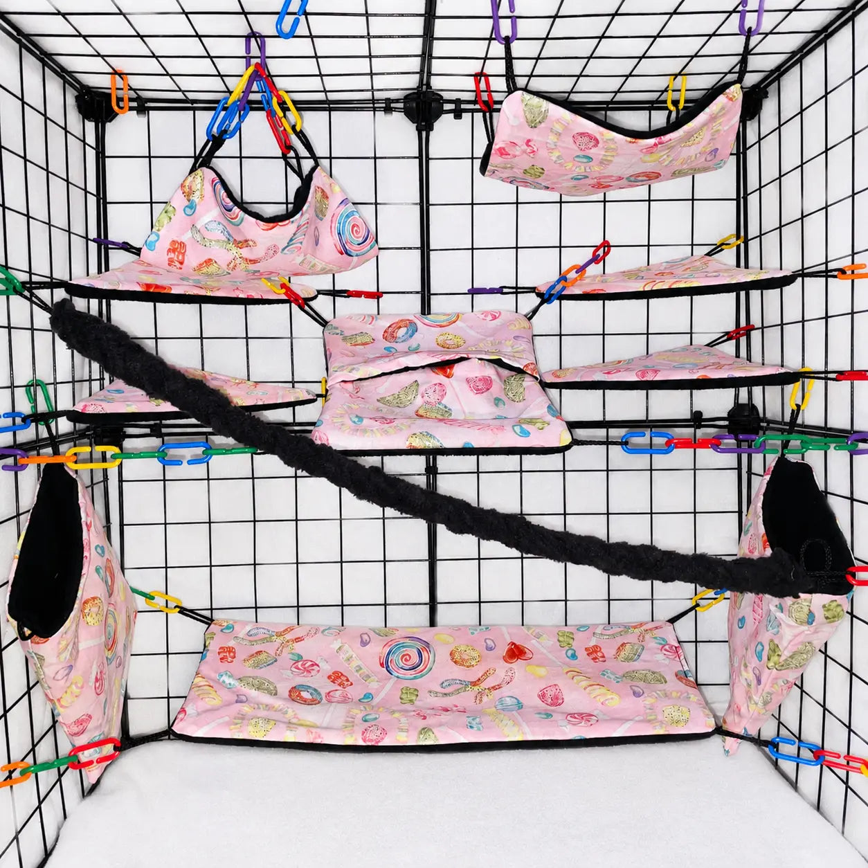 Pink candy print sugar glider cage set with hammocks, pouches, bridges, shelf liners, and black fleece vine.