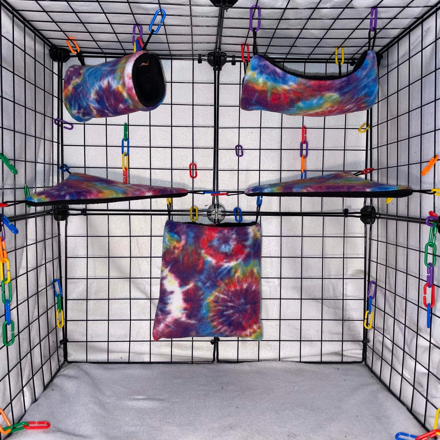 Rainbow tie-dye sugar glider expansion set with tunnel, hammock, shelves, and fleece accessories. Handmade cage add-ons for cozy glider play.