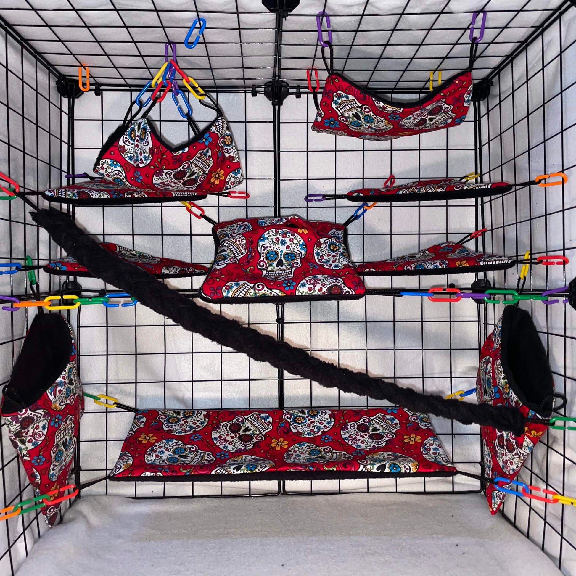 Red sugar skull sugar glider cage set with black fleece for interior of pouches, hammocks, shelves, bridge, and braided rope inside a display cage.