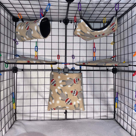 Sock monkey print sugar glider fleece expansion set with pouch, hammock, tunnel, and corner shelves installed in a wire cage.
