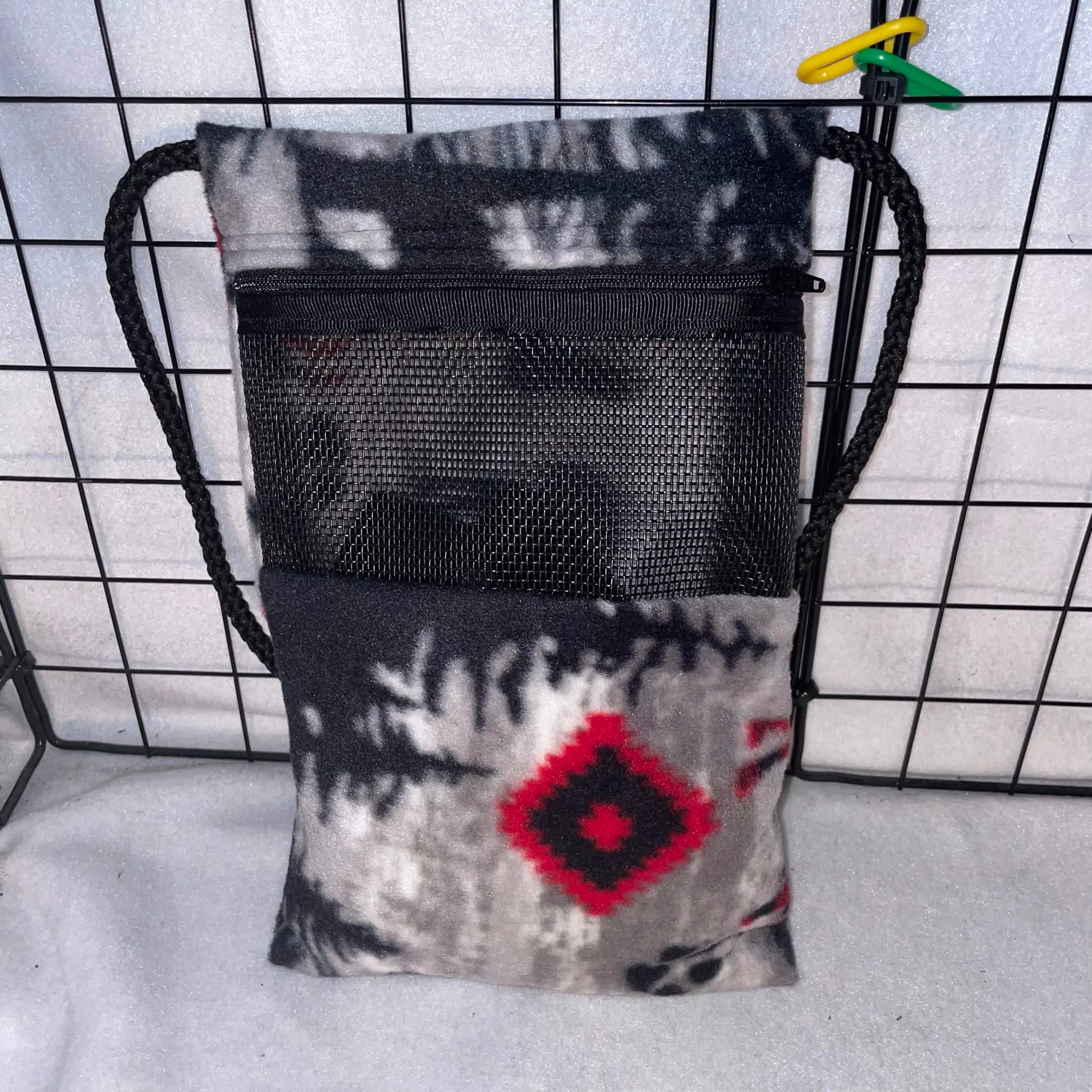 Southwestern print sugar glider bonding pouch with black mesh window and shoulder strap shown inside a display cage.