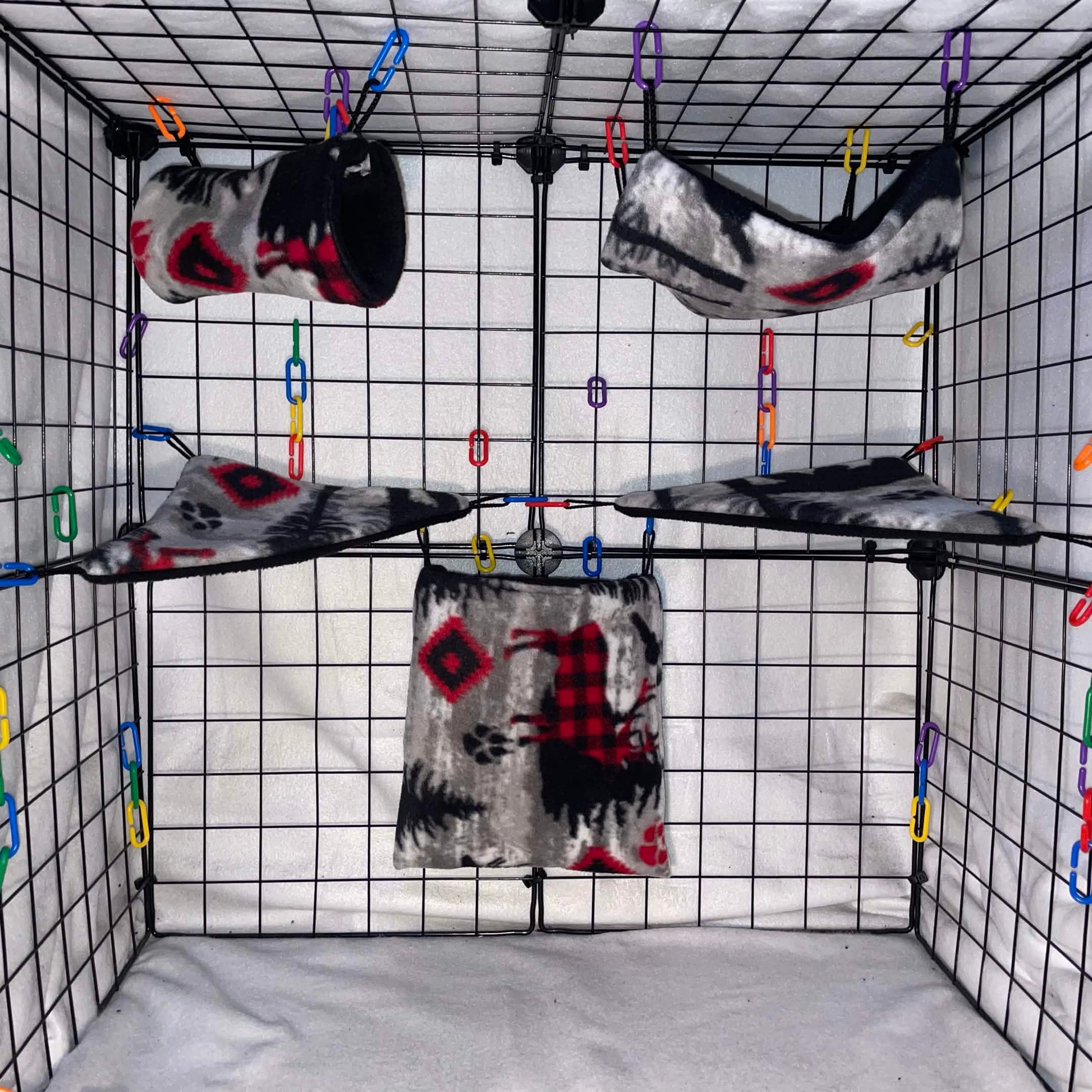 Woodsman print sugar glider cage set with black interior, hammocks, tunnel, pouch, and corner shelves shown in a display cage.